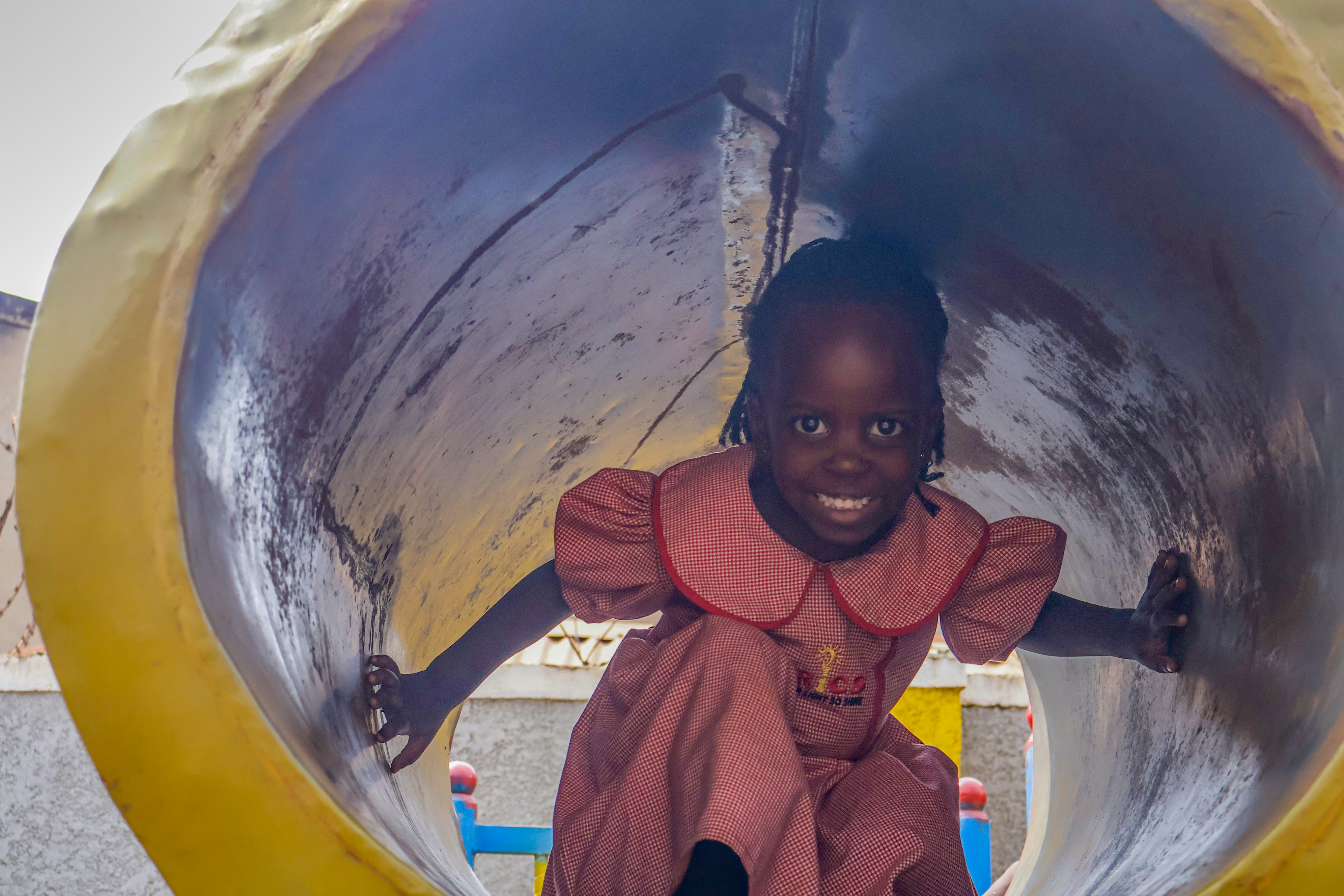Student laughing while climbing through the tunnel slide